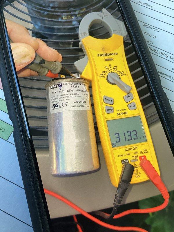 Completed annual cooling maintenance on two HVAC systems as part of membership plan. Performed comprehensive tune-up on both outdoor condensing units and indoor air handlers. Tested and measured capacitor performance using digital multimeter, verifying MARS 35x5.0 μF dual-run capacitor operating within specifications at 440VAC. Recorded amperage draw of 3.133 amps on compressor circuit, confirming normal operating parameters. Inspected condenser coils for cleanliness and airflow restrictions, noting minor dust accumulation with normal coloration. Verified refrigerant line insulation integrity on copper lines. Accessed basement mechanical room to inspect furnace and air handler components. Checked all electrical connections, contactors, and safety controls on both systems. Verified proper drainage from condensate lines and inspected PVC piping for blockages. Provided guidance on energy-saving practices regarding nighttime thermostat setback versus opening windows and shutting off AC sys