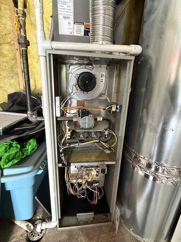 Responded to service call for furnace making excessive noise described as extremely loud operational sounds. Upon inspection, diagnosed failed blower motor bearings resulting in bent blower motor shaft and damaged blower wheel on 2008 furnace unit. Documented existing Lennox AC condenser unit located exterior and photographed furnace cabinet interior showing damaged blower assembly and mechanical components. Provided tech lead assessment and ballpark estimate for complete furnace replacement due to extent of mechanical failure and age of existing equipment.