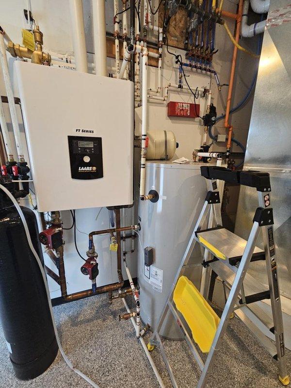 Performed diagnostic inspection on water softener system less than one year old experiencing operational issues. Evaluated irrigation line manifold requiring rerouting and inspected failing check valve. Examined plumbing infrastructure including PEX piping, pressure tank, brass fittings, and pump assembly with digital controls. Documented system configuration and identified necessary repairs to restore proper water conditioning function and resolve check valve failure.