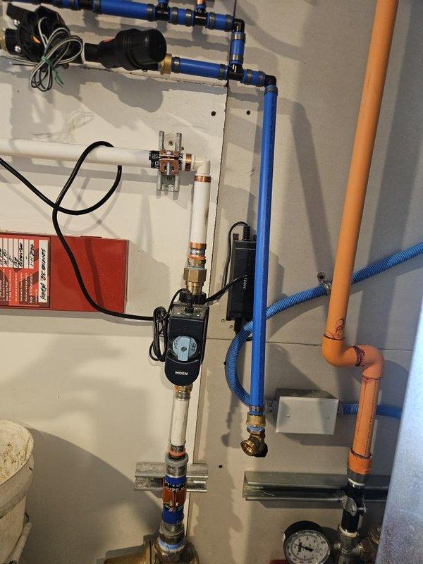 Performed diagnostic inspection on water softener system less than one year old experiencing operational issues. Evaluated irrigation line manifold requiring rerouting and inspected failing check valve. Examined plumbing infrastructure including PEX piping, pressure tank, brass fittings, and pump assembly with digital controls. Documented system configuration and identified necessary repairs to restore proper water conditioning function and resolve check valve failure.