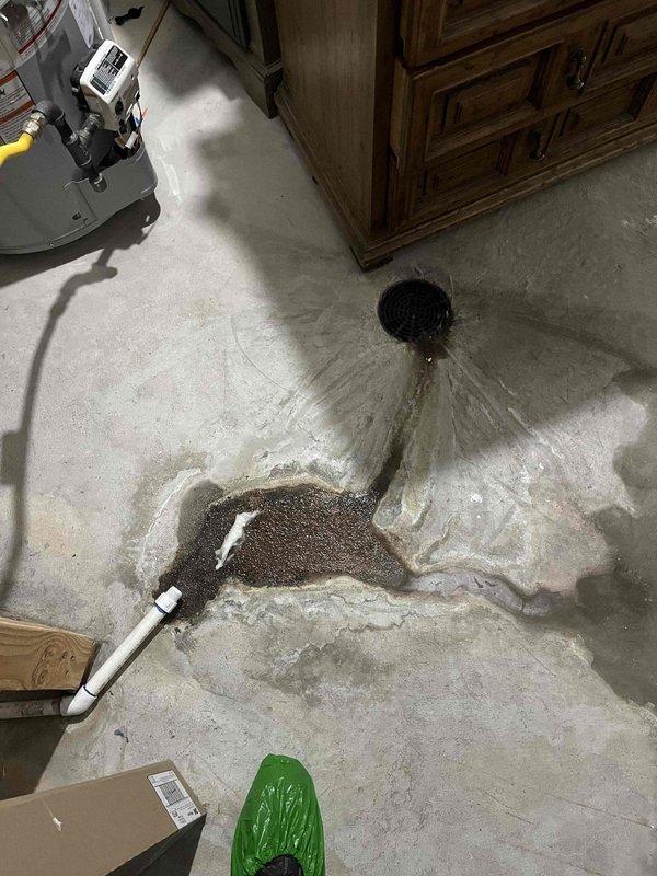 Responded to reported water leak with suspected dishwasher source causing wall and floor damage. Upon arrival, found significant water accumulation on basement concrete floor with active pooling near floor drain and moisture damage extending across multiple areas. Documented extensive water intrusion affecting flooring and baseboards, with visible saturation patterns indicating ongoing leak requiring source identification and remediation.