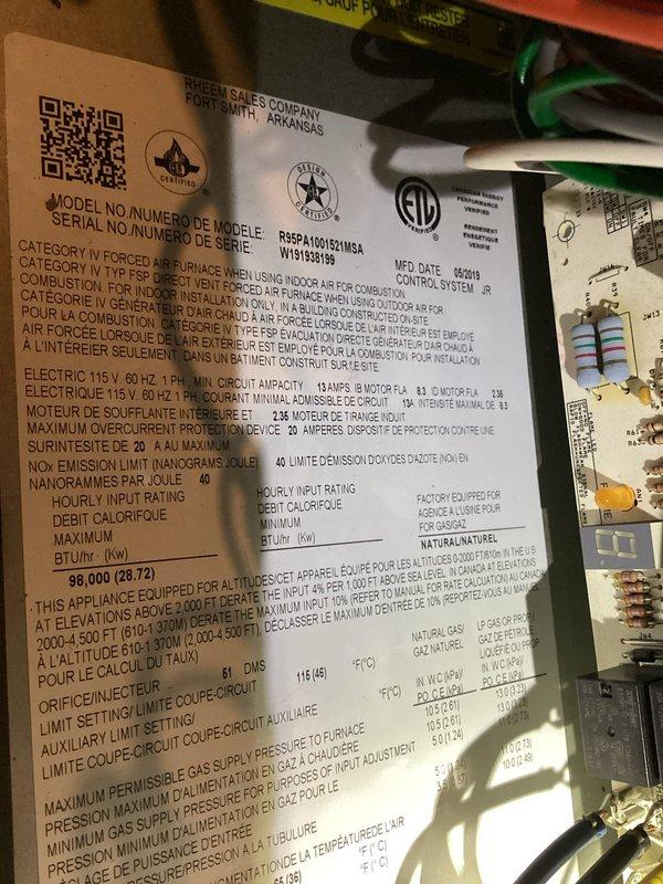 Responded to no cooling complaint on 6-7 year old residential air conditioning system. Performed diagnostic evaluation of Ruud furnace/air handler unit located in basement and outdoor condensing unit on side of property. Inspected electrical connections, control board, and gas line connections on indoor unit. Documented equipment specifications and current operating conditions through visual inspection and photography of nameplate data showing 96,000 BTU/HR input rating and 115V electrical requirements. Completed system assessment to determine cause of AC failure to start.