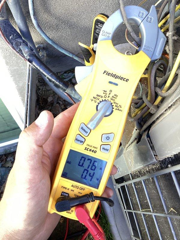 Responded to no cooling complaint on 10+ year old residential air conditioning system. Upon arrival, located outdoor condenser unit in backyard and performed diagnostic testing using digital multimeter to check electrical values and system operation. Inspected older model condenser unit with weathered casing, verified proper placement on concrete pad, and assessed overall equipment condition including exposed electrical connections and conduit. Documented system readings and equipment status with photos showing diagnostic measurements and unit configuration.