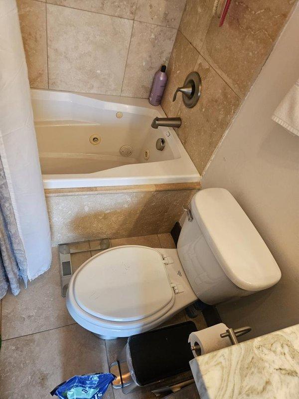 Responded to emergency call for active water leak penetrating ceiling and light fixtures in kitchen and bathroom areas. Upon inspection, identified water damage on ceiling surfaces with visible staining, cracking, and moisture intrusion patterns. Located source of leak and performed necessary repairs to stop active water flow. Documented damage to affected areas including ceiling deterioration and compromised drywall surfaces in bathroom vicinity.