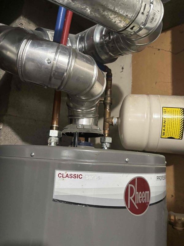 Responded to no hot water call for Rheem Classic Series tanked water heater located in basement. Diagnosed pilot light failure that would not stay lit after ignition attempts. Inspected gas control valve assembly, thermocouple, and pilot assembly on 3-5 year old unit. Addressed faulty flame sensor preventing pilot from remaining lit, restored proper gas flow to pilot assembly, and verified temperature control dial functionality. Tested system operation and confirmed sustained pilot flame and burner ignition, restoring hot water to property.