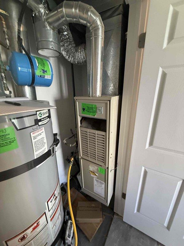 Conducted HVAC system evaluation for residential property in preparation for home sale after inspector identified aging equipment. Assessed existing 20+ year old forced-air furnace unit located in utility closet alongside water heater, documented current system configuration including ductwork and gas line connections. Provided comprehensive replacement estimate for new HVAC system with installation timeline scheduled before winter season.