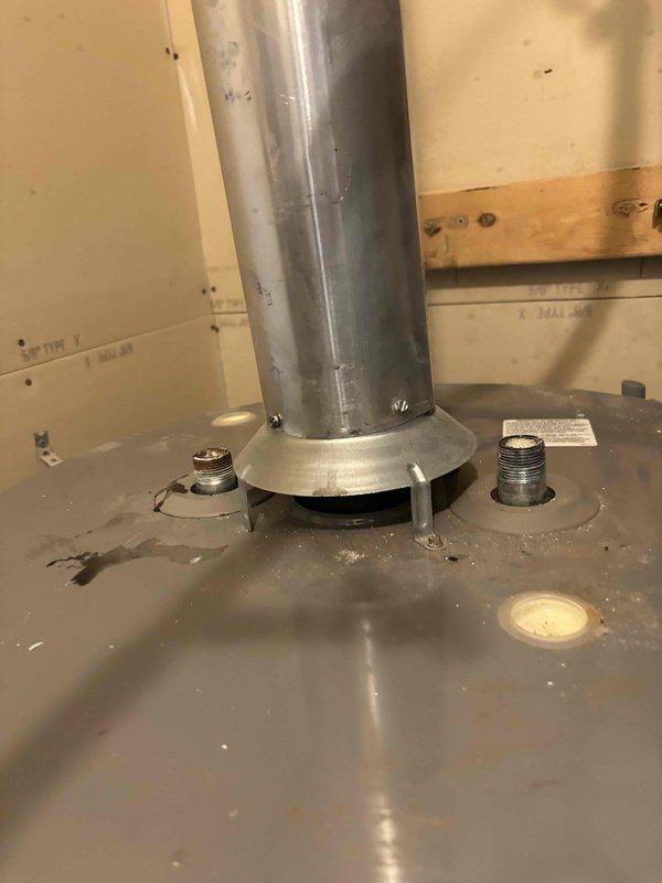 Responded to service call for dual water heater system experiencing water hammer noise and ignition failure. Inspected 6-year-old Rheem 50-gallon tanked unit located in upstairs utility closet that was displaying valve failure error code and failing to relight since April. Diagnosed water hammer issue occurring when hot water fixtures are used simultaneously throughout home. Examined tank interior, flue venting system, and gas valve assembly. Documented condition of installation including flexible gas connector, mounting configuration, and venting penetration through roof assembly. Assessed both water heaters to determine cause of simultaneous fixture operation creating pressure surge and evaluated non-functioning unit's ignition system and gas valve operation per manufacturer specifications.