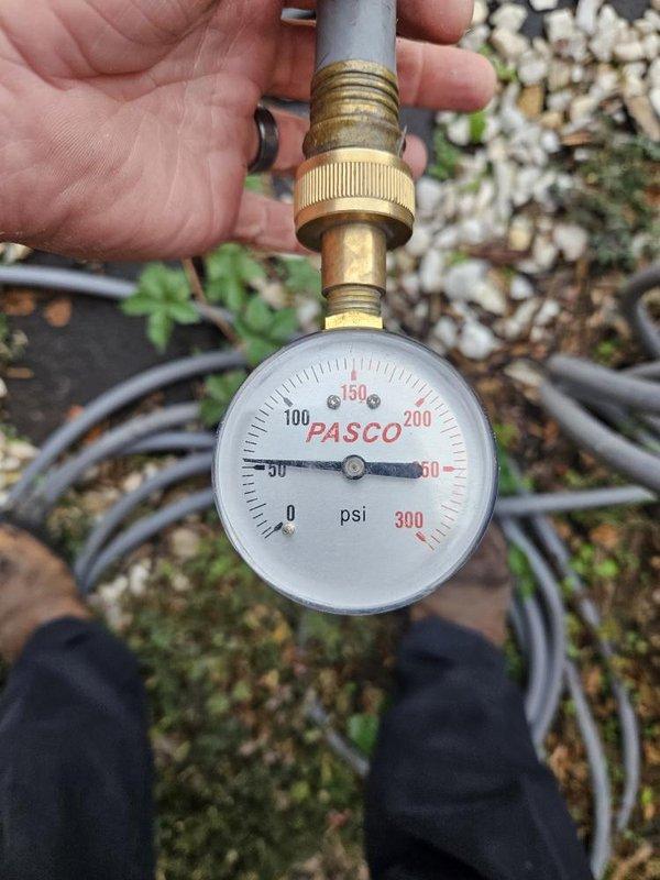 Responded to a malfunctioning 6+ year old gas tank water heater in the basement northwest corner that was providing minimal hot water and actively leaking from underneath the unit. Performed diagnostic inspection of the water heater system, tested pressure levels using calibration gauge, and assessed the copper supply and discharge plumbing connections with shutoff valves. Documented the condition of the failed water heater unit and associated plumbing infrastructure for replacement recommendation.