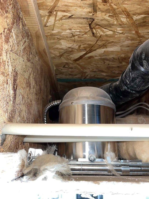 Responded to reported water leak originating from shower and penetrating to basement below. Upon inspection, accessed structural cavity between floors and identified compromised plumbing connections and deteriorated flexible drainage components. Documented existing conditions showing damaged black corrugated drain line with visible tears and deterioration, white PVC drainage pipes crossing through floor joists, and evidence of water intrusion in the structural space. Assessed mechanical systems, ductwork, and insulation in affected area to determine extent of leak damage and necessary repairs.