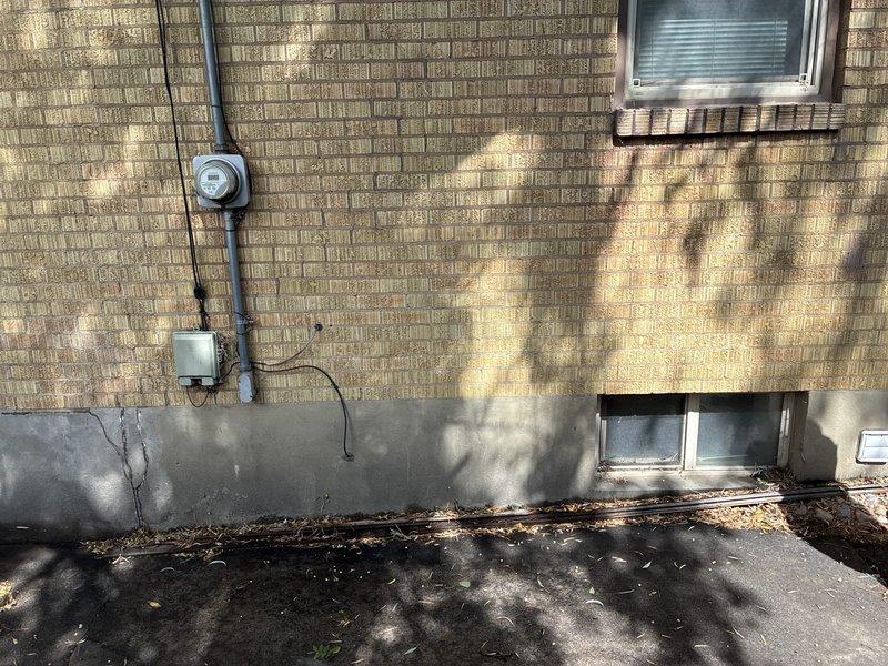 Conducted site evaluation for electrical service upgrade from existing configuration to 200 amp main service with 100 amp subpanel replacement. Inspected current exterior meter base, service entrance conduit, and main distribution panel to assess existing infrastructure and determine scope of work required. Documented current electrical system configuration including panel interior showing multiple circuit breakers, wire routing, and bus bar connections. Photographed exterior service equipment mounted on residential foundation wall and interior panel components to provide comprehensive visual documentation for estimate preparation. Identified necessary materials and labor requirements for complete service upgrade installation.