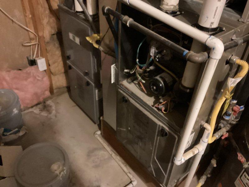 Responded to service call for 10-year-old air conditioning system experiencing insufficient airflow through vents and evaporator coil freezing on one of two units. Upon arrival, accessed basement-located HVAC equipment and performed comprehensive Cool 10+ preventive maintenance inspection. Examined blower motor assembly and electrical connections, inspecting for reported electrical issues including potential shorts or fuse problems. Evaluated evaporator coil condition and checked for airflow restrictions that could contribute to freezing. Verified blower motor operation and amperage draw. Inspected all wire connections to motor assembly and control board. Checked air filter condition and ductwork for obstructions affecting system airflow. Assessed refrigerant levels and system pressures to determine cause of coil freezing. Cleaned accessible components and verified proper system operation. Documented equipment condition with photographs showing internal furnace components, blower motor