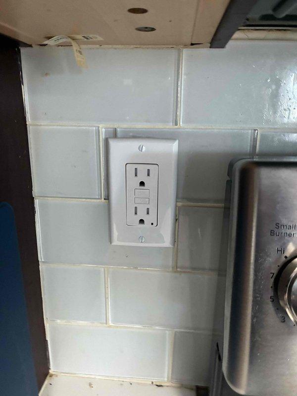 Completed full electrical service including installation and testing of GFCI outlets in two locations. Installed weatherproof GFCI receptacle with cover on exterior brick wall and replaced kitchen backsplash outlet with GFCI protection near cooking appliance to meet current safety code requirements.