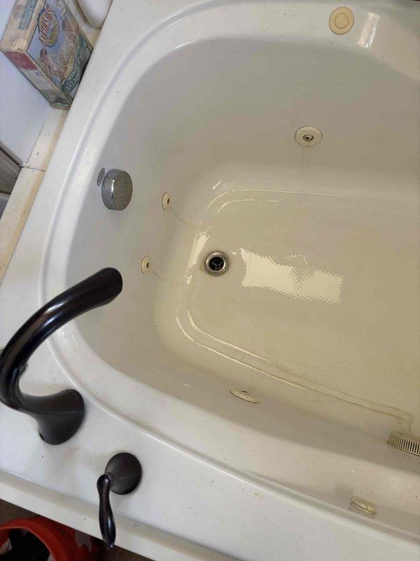 Responded to clogged bathtub drain in second-floor bathroom with stuck drain plug preventing normal drainage and snake access. Removed stuck drain plug mechanism from corner jetted tub and cleared obstruction from drain line. Restored proper drainage function and verified water flow through drain system.