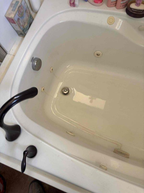 Responded to clogged bathtub drain in second-floor bathroom with stuck drain plug preventing normal drainage and snake access. Removed stuck drain plug mechanism from corner jetted tub and cleared obstruction from drain line. Restored proper drainage function and verified water flow through drain system.
