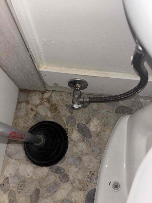 Responded to reported leak in basement ceiling originating from upstairs bathroom. Upon inspection, identified source as faulty shower diverter valve with compromised seals causing water intrusion through ceiling below. Documented existing conditions with photos showing chrome-plated shower valve assembly with visible moisture accumulation and bathroom plumbing fixtures. Assessed water damage to basement ceiling and confirmed active leak path from bathroom floor penetration.