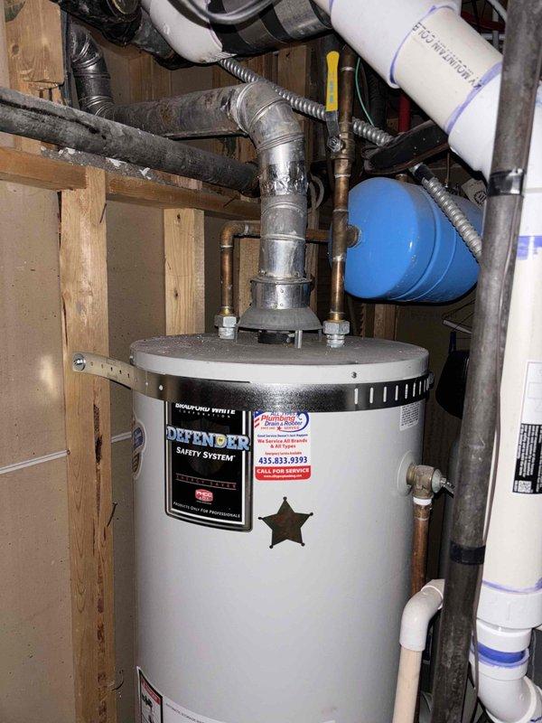 Completed sewer line assessment at vacant residential property for prospective buyer requiring replacement estimate. Conducted thorough exterior and interior inspection of plumbing infrastructure, documenting existing water heater installation with Defender Safety System, associated PVC drainage lines, and pressure relief components in utility area. Evaluated exterior plumbing access points and sewer line routing to determine scope of replacement work needed for property transaction purposes.