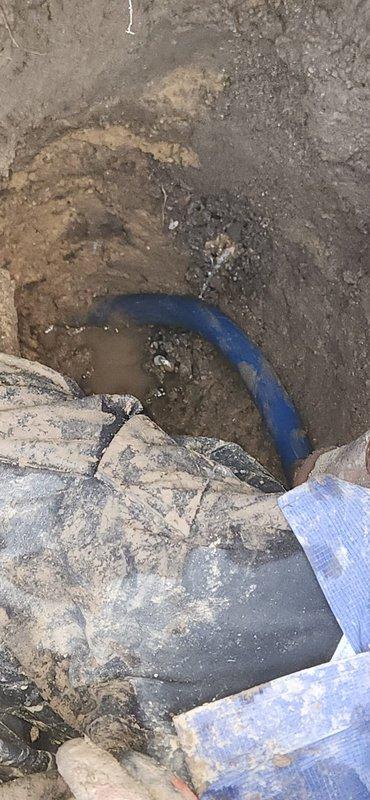 Completed warranty repair on main culinary water line outside residence. Excavated trench to expose compromised section of main water line, removed damaged pipe segment, and installed new blue PVC pipe with proper fittings and connections using beige coupling sections and gray threaded adapters. Backfilled excavation and restored site upon completion of spot repair.