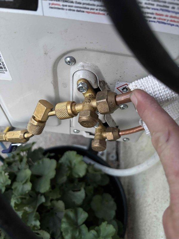 Responded to service call for a 3-month-old DIY mini-split system experiencing cooling issues after homeowner extended line set from 15 to 25 feet. Upon inspection, accessed service valves on outdoor unit located on north wall and assessed refrigerant charge levels. Added R-32 refrigerant to compensate for additional line set length and bring system to proper operating charge. Verified system operation and cooling performance after recharge. Noted evidence of debris accumulation on interior access panel during service.