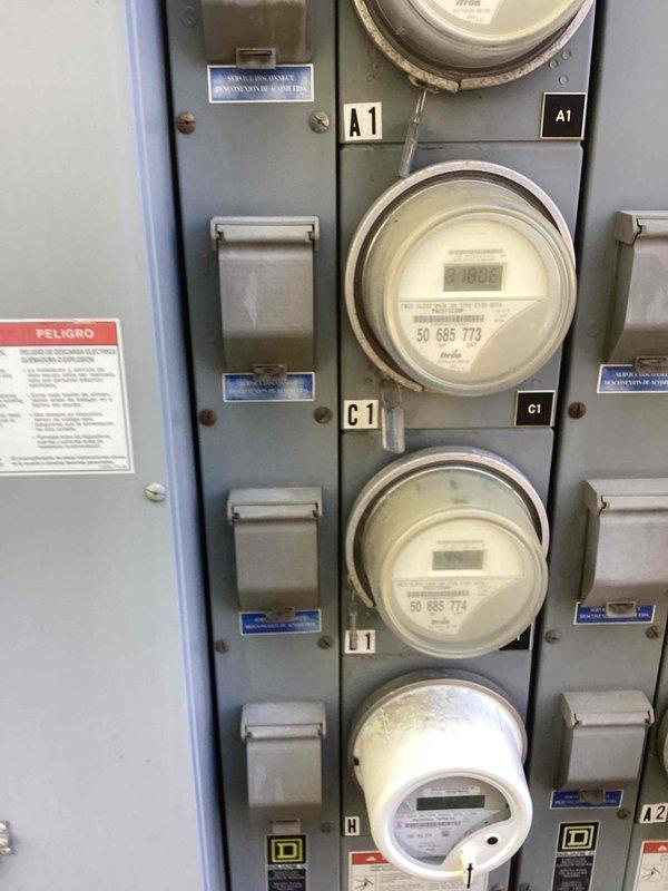 Completed routine electrical maintenance inspection for multi-unit residential property. Inspected exterior electrical meter panel containing multiple Itron digital utility meters serving units A1, C1, and H, verifying proper operation and secure mounting. Performed interior inspection of main electrical panel, checking all circuit breakers for proper function, examining bus bar connections, and verifying wire terminations were secure with no signs of overheating or damage.