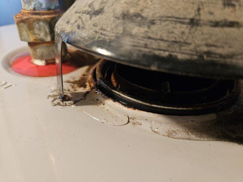 Responded to service call for leaking water heater in basement utility room. Upon inspection, identified active leak originating from top connections of 12+ year old tanked water heater with visible corrosion and rust present at base fittings and drain valve area. Provided customer with replacement options for consideration.