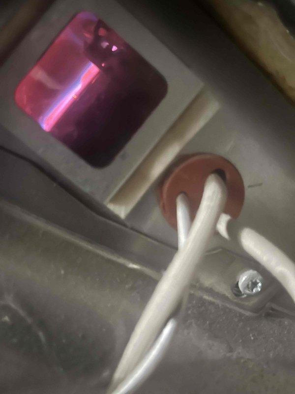 Responded to no hot water complaint on 6-year-old tanked water heater in basement. Upon inspection, observed water heater with exposed shut-off valve assembly and heating element through viewing window showing active ignition. Documented existing plumbing configuration including supply lines and main shut-off valve mounted to access panel. Inspected heating element operation and verified gas supply connections through access port, noting proper ignition sequence with visible flame present.