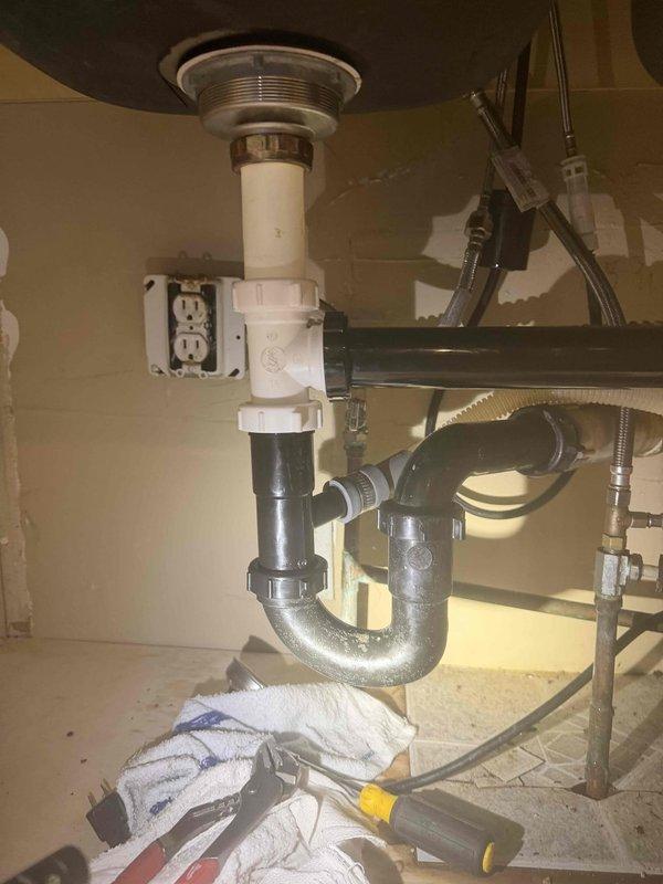 Responded to service call for malfunctioning and leaking garbage disposal in kitchen. Upon inspection, assessed the existing disposal unit and associated plumbing connections, including mounting assembly, discharge piping, and water supply lines. Evaluated the condition of the disposal, P-trap configuration, and drain connections to determine appropriate repair or replacement solution. Documented existing installation showing signs of age and wear on mounting hardware and connections.