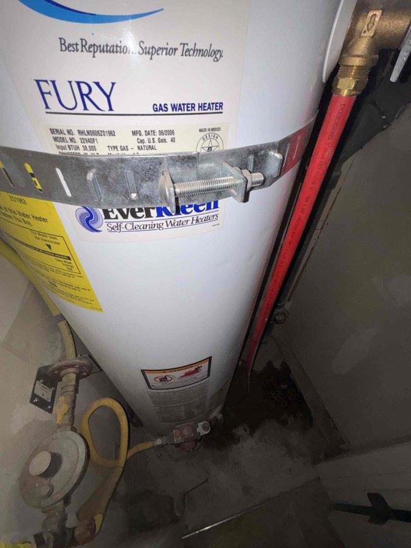 Responded to service call for leaking gas water heater. Upon arrival, inspected 40-gallon Fury gas water heater manufactured in 2005, approximately 20 years old, located in closet adjacent to laundry room. Unit exhibited active leaking from bottom of tank, indicating internal tank failure. Documented existing installation including gas supply connections, water supply piping with brass fittings, pressure relief valve, and pressure gauge assembly reading zero PSI. Assessed overall system configuration and clearances for replacement planning. Provided customer with replacement estimate for new gas water heater installation, as tank leaks are non-repairable and unit has exceeded typical service life expectancy. No diagnostic work performed per customer request for replacement estimate only.