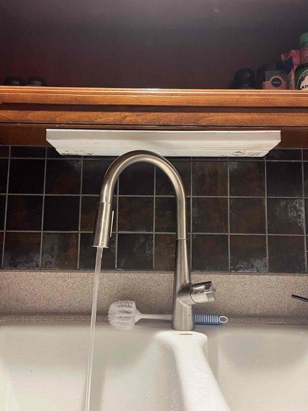 Responded to downstairs kitchen sink backup that had persisted for approximately one week. Upon arrival, confirmed water was draining normally from main kitchen sink but backing up into lower level kitchen sink. Inspected under-sink plumbing and recently installed garbage disposal unit. Performed professional cable snaking of the affected drain line to clear blockage causing the backup condition. Verified proper drainage flow restored to downstairs kitchen sink upon completion of rooting service.