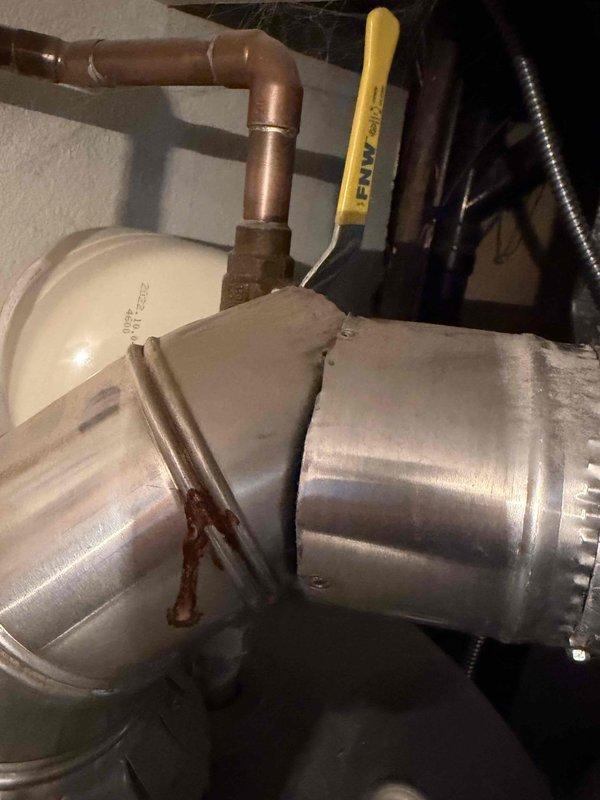 Responded to service call for discolored water issue and performed non-member plumbing inspection. Upon arrival, assessed water heater system and surrounding plumbing connections to diagnose cause of yellow-tinted water. Inspected copper piping, HVAC ductwork connections, and mechanical components in utility space, noting rust deposits and oxidation on duct seams that could indicate moisture infiltration in the area. Documented existing conditions of plumbing infrastructure including copper lines, PVC drainage, and water heater connections to provide comprehensive assessment for recommended water heater flush service.