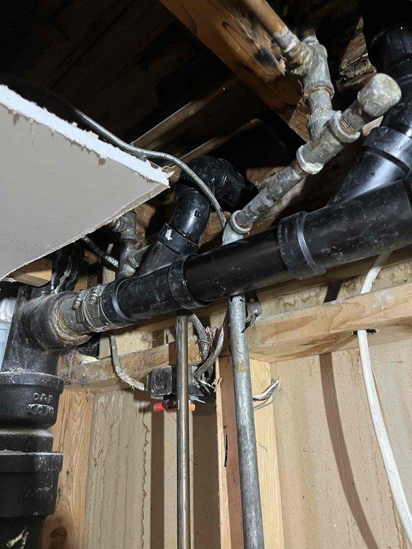 Replaced waste and overflow assembly for shower/tub combination with new properly graded piping and P-trap. Accessed drain lines through ceiling opening below fixture, installed new black ABS drain piping with appropriate fittings and secured all lines to structural framing per code requirements. Sink drain line replacement was also completed as part of the scope to ensure proper drainage throughout the bathroom.