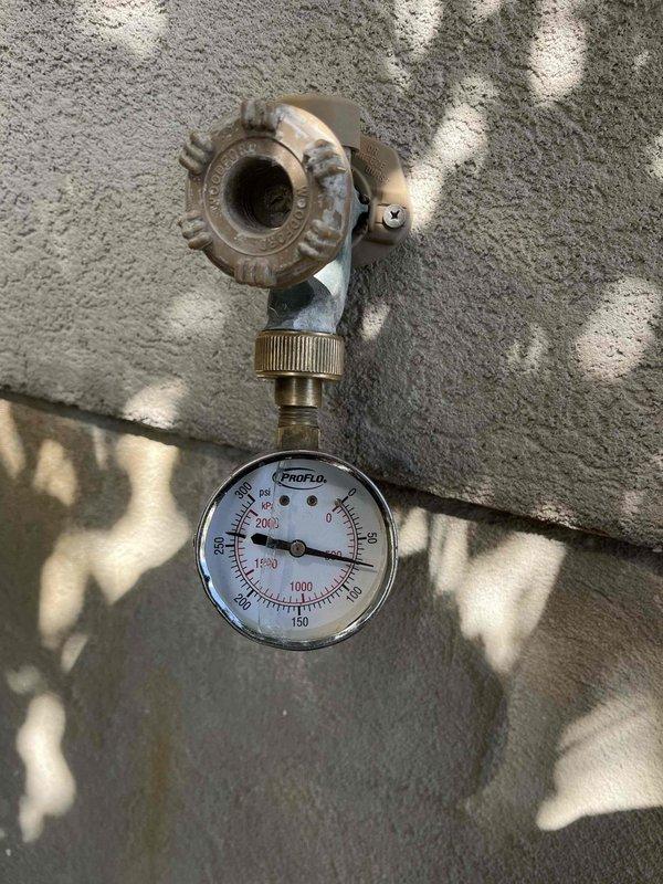 Responded to a leaking 6-year-old tanked water heater with leak originating from the top of the unit. Upon inspection, identified the pressure relief valve (PRV) as the probable source of the leak. Noted that an expansion tank had been previously installed on top of the water heater. Assessed the PRV assembly and pressure gauge components to determine necessary repairs for resolving the water leakage issue.