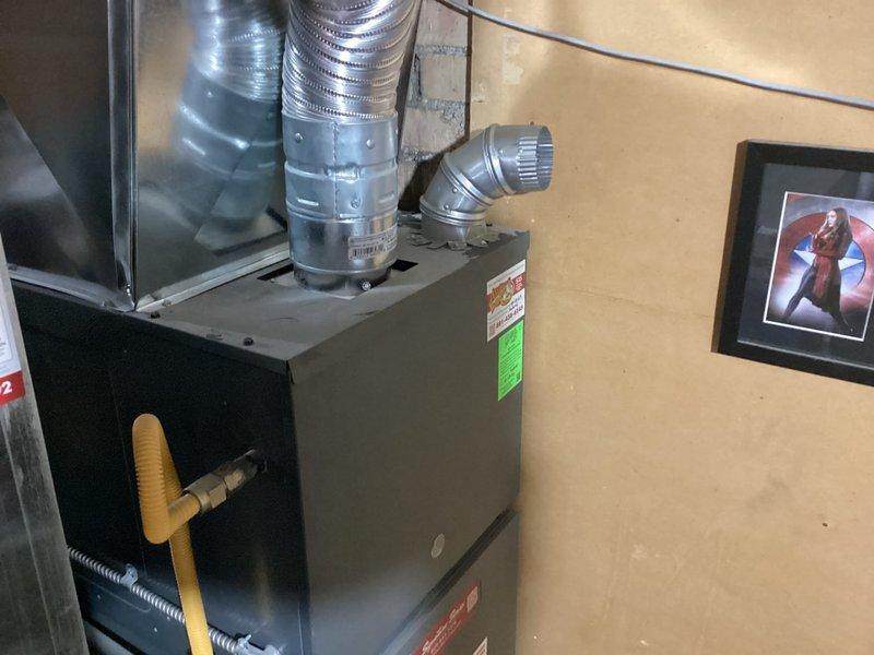 Performed routine maintenance on residential furnace system in basement utility area. Tested and verified flame sensor operation with multimeter, recording reading of 48.5 microamps to confirm proper flame detection functionality. Replaced air filter and inspected gas lines, ductwork connections, and overall system operation to ensure safe and efficient performance.