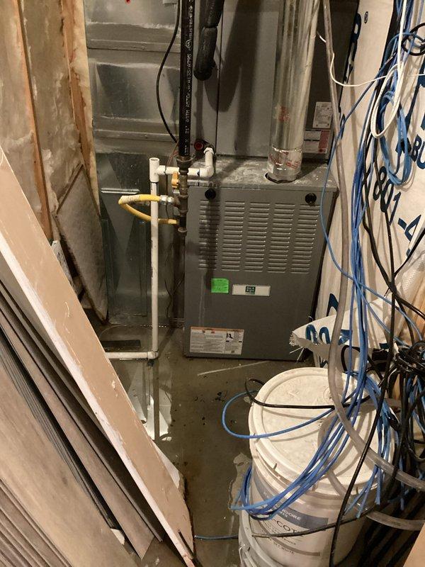 Responded to emergency call for water leak from furnace creating significant flooding in basement utility area. Upon inspection, determined leak was originating from condensate drainage system on 5-6 year old furnace unit. Found condensate drain line clogged, causing backup and overflow that resulted in extensive standing water accumulation around furnace and water heater. Cleared blockage from condensate drain line and PVC piping, verified proper drainage flow restored, and tested system operation to ensure no further leakage. Advised on water extraction needs for flooded area and recommended monitoring condensate system regularly to prevent future occurrences.