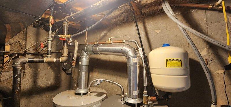Installed 50-gallon residential water heater in basement mechanical room with full code compliance including proper venting system, gas line connections, expansion tank, earthquake restraint straps, new copper supply lines, and shutoff valve. Removed and disposed of existing water heater, completed all connections per manufacturer specifications, performed system light-off and operational testing to verify proper function and safety of new unit with 6-year manufacturer warranty coverage.