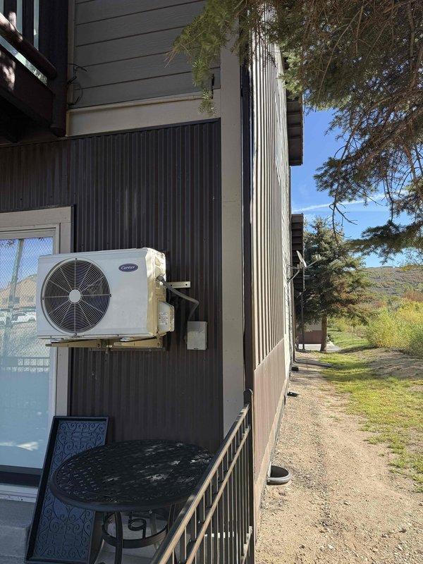 Evaluated existing non-functioning air conditioning system and provided estimate for mini-split installation to serve single room. Assessed current outdoor condenser unit mounted on exterior wall with refrigerant line set, and inspected indoor portable AC unit currently in use within the space. Discussed mini-split system options as replacement solution for failed existing equipment, reviewed installation requirements including outdoor condenser placement and indoor air handler positioning, and presented equipment specifications and financing options to facilitate timely system replacement.