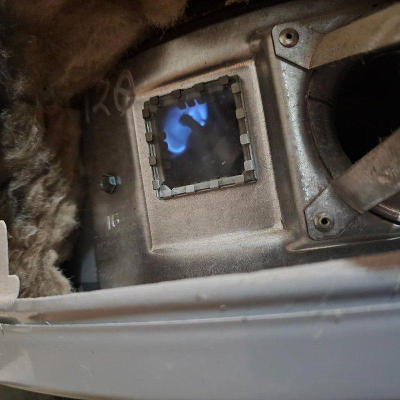 Responded to no hot water complaint on 6-year-old tank-style water heater located in basement. Upon inspection, found unit with operational burner assembly showing proper combustion with blue flame pattern visible through viewing port. Verified gas supply, ignition system, and burner operation were functioning correctly, restoring hot water service to the home.