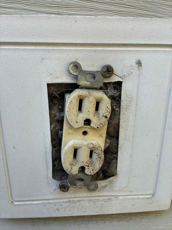 Completed annual electrical maintenance visit as part of ongoing membership preventative maintenance program. Performed comprehensive electrical system inspection including panel evaluation and outlet testing throughout the property. Tested interior and exterior receptacles using digital multimeter, verifying proper voltage, grounding, and polarity. Identified exterior outlet showing significant environmental deterioration with visible corrosion on mounting hardware and discoloration on receptacle face, indicating prolonged moisture exposure and weathering. All tested circuits showed correct 120 VAC readings with proper hot, neutral, and ground connections. Documented conditions with photographic evidence for maintenance records.
