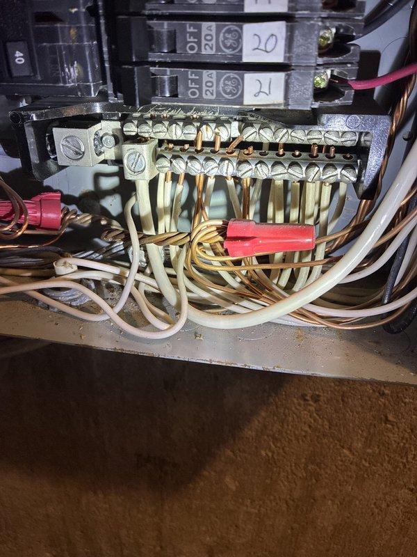 Completed annual preventative electrical maintenance inspection as part of recurring membership service. Performed comprehensive evaluation of main electrical panel, circuit breakers, and all visible wiring connections. Inspection revealed oxidation and yellowish-brown discoloration on multiple breaker terminals, particularly on breaker #5, indicating age-related corrosion at connection points. Examined terminal block assembly with multiple wire connections and verified proper wire bundling and organization. Documented panel condition showing standard residential circuit breaker configuration with numbered breakers and color-coded wiring throughout. All circuit breakers operational with no tripping issues reported. Noted general age-related wear on components but no immediate safety concerns requiring emergency repair. Photographed panel interior and terminal connections for maintenance records.