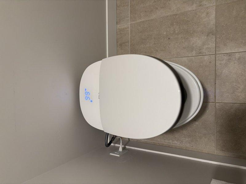 Completed toilet replacement in residential bathroom. Removed existing toilet fixture and installed new modern dual-flush toilet with chrome flush lever and digital display feature. Secured unit to floor flange, connected water supply line, and tested flush mechanism for proper operation. Verified all seals for leaks and confirmed stable mounting. Left work area clean with new fixture fully operational.