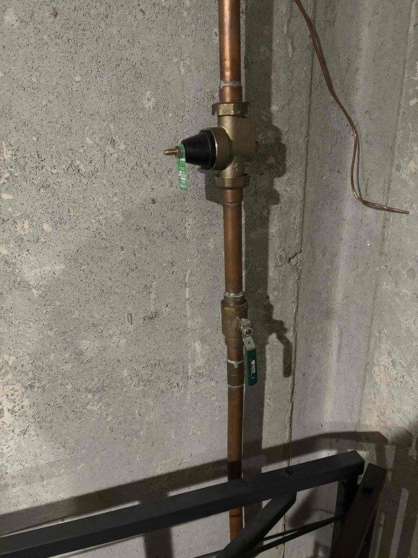 Responded to follow-up service call for water heater leak that developed after previously quoted components failed. Accessed wall cavity and replaced defective brass fittings and connector assembly on supply line. Installed new compression fittings on copper piping, secured shut-off valve with proper sealing, and restored water supply connections to eliminate active leak.