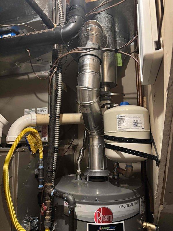 Removed existing water heater and installed new 40-gallon Rheem Professional Series unit in utility closet with full code compliance including proper venting, expansion tank, seismic restraint straps, new supply lines, and new shut-off valve. Connected gas supply line, installed aluminum exhaust flue with proper vertical venting configuration, and verified all plumbing connections for leaks. Lit pilot, tested unit operation, and confirmed proper hot water delivery throughout system.