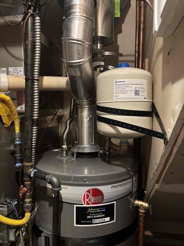 Removed existing water heater and installed new 40-gallon Rheem Professional Series unit in utility closet with full code compliance including proper venting, expansion tank, seismic restraint straps, new supply lines, and new shut-off valve. Connected gas supply line, installed aluminum exhaust flue with proper vertical venting configuration, and verified all plumbing connections for leaks. Lit pilot, tested unit operation, and confirmed proper hot water delivery throughout system.