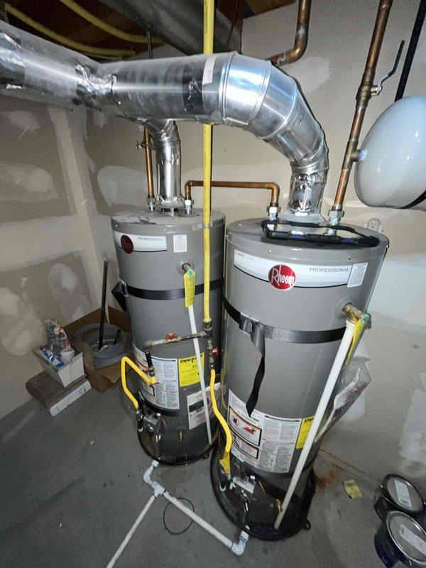 Completed annual plumbing maintenance inspection including pressure test, water purity test, and water heater flush on dual Rheem Professional water heater system. Both 8-year-old units inspected and serviced with proper venting, gas line connections, copper piping, and expansion tank verified to be in working order.