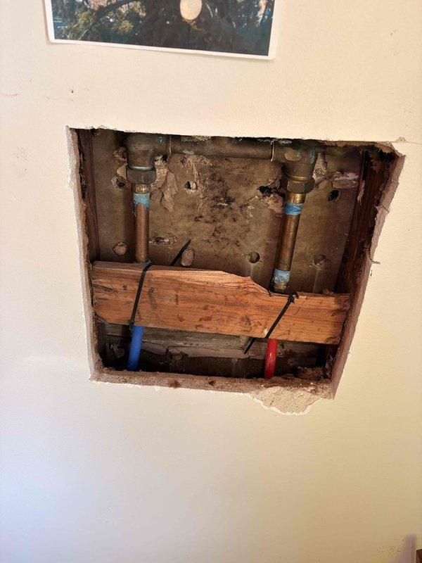 Responded to reported shower leak in main bathroom. Upon inspection, accessed plumbing behind wall to identify source of water leakage. Examined shower valve assembly, supply lines, and connections. Repaired/replaced faulty components causing the leak. Verified proper operation of shower controls and handheld showerhead system. Tested all connections for leaks and confirmed repair resolved the issue.