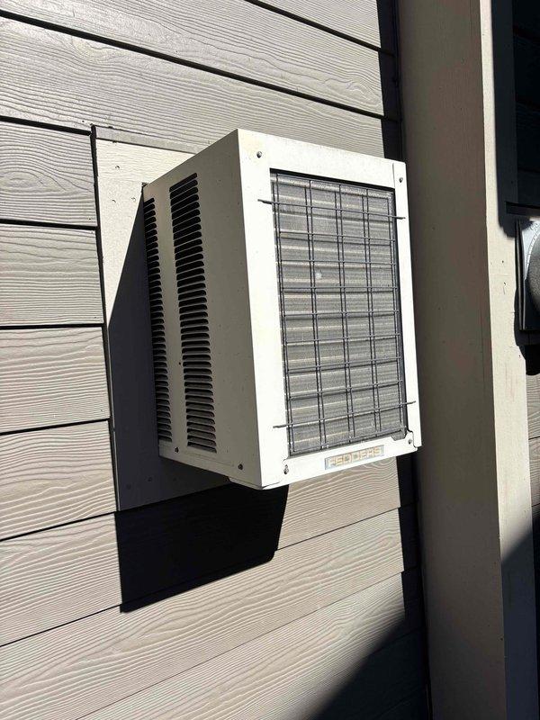 Conducted on-site evaluation of existing through-wall air conditioning unit for potential replacement. Unit is 10+ years old, potentially up to 40 years, and currently experiencing cooling issues. Assessed installation requirements and sizing constraints for replacement options, as property has limited availability for standard-sized through-wall units. Documented existing ductless mini-split outdoor condenser installation on exterior wall with horizontal siding. Photographed current equipment configuration, mounting setup, and ventilation components. Provided consultation on replacement alternatives and coordinated with property management regarding similar units across multiple properties for future consideration.