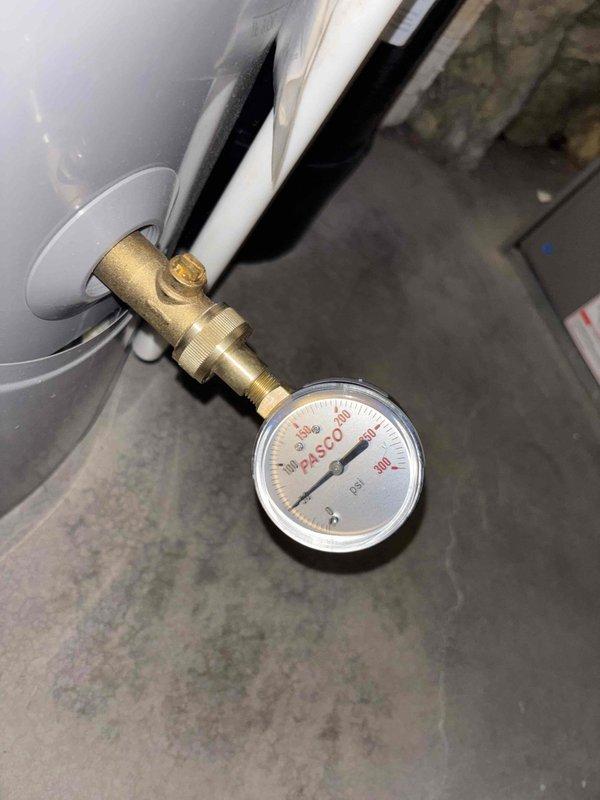 Performed membership plumbing inspection and water heater flush on 4-year-old tank-style unit located in basement. Inspected pressure relief valve assembly with gauge reading at zero PSI, verified brass fittings and connections for proper operation. Completed routine water heater maintenance including sediment flush, examined all copper piping connections and flexible supply lines for leaks or deterioration, and confirmed proper venting through galvanized ductwork elbow assembly.