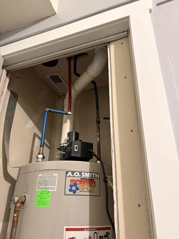 Responded to reported intermittent leak from top fixtures and drip pan of 20-year-old A.O. Smith tank-style water heater in garage utility closet causing water damage to adjacent property. Inspected unit and all connections including top-mounted brass fittings, PEX supply lines, and drip pan assembly. Evaluated overall condition of aging water heater and provided assessment for leak repair versus full unit replacement due to age and extent of water intrusion.