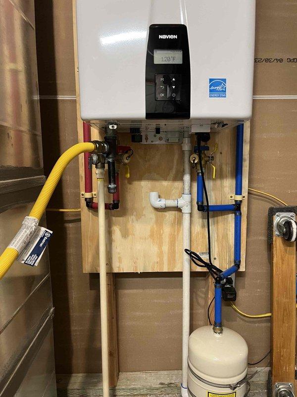 Installed Navien NPE-240A tankless water heater to replace existing unit. Ran 2" PVC venting system for exhaust and fresh air intake per code requirements. Extended 3/4" gas line with yellow CSST to unit location and installed shut-off valve. Installed 3/4" PEX hot and cold water lines with isolation ball valves for future service access. Mounted expansion tank and made all necessary electrical connections. Removed old water heater, tested new unit for proper operation, and verified all connections for leaks. Unit is operational with 5-year manufacturer warranty and 15-year heat exchanger warranty.