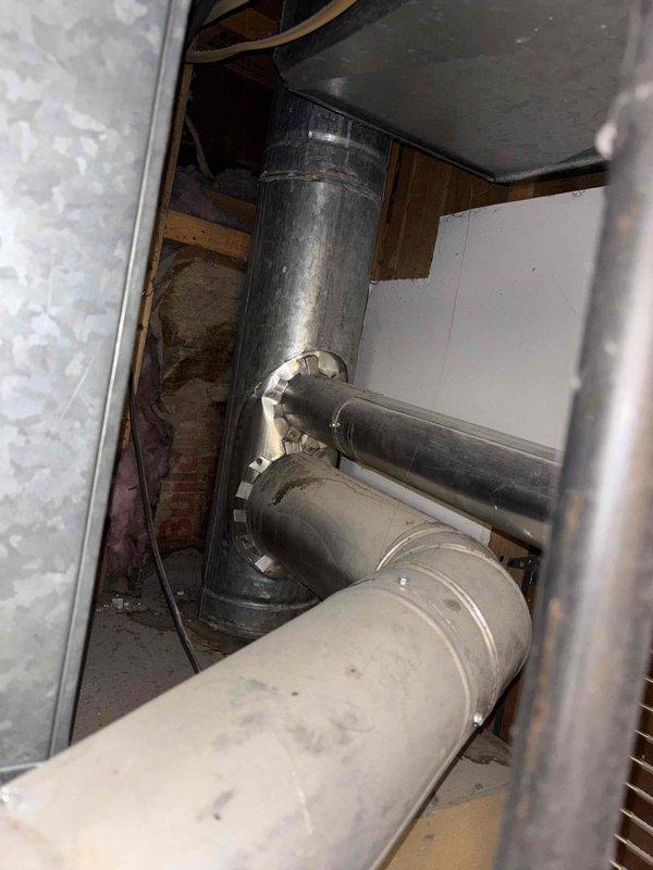 Responded to service call for non-functioning tank-style water heater over 6 years old located in garage area. Performed comprehensive assessment of existing water heater system and surrounding plumbing infrastructure, including examination of copper supply lines, shut-off valves, and connection points. Inspected plumbing configuration featuring vertical and horizontal copper pipe runs with blue-handled shut-off valve, noting aged copper with typical oxidation and patina. Evaluated installation accessibility through garage entry point and assessed crawl space area containing HVAC ductwork and structural components that may impact removal and replacement procedures. Documented existing plumbing connections, pipe sizing, and current water heater specifications. Provided detailed estimate options for tank water heater replacement, including various tank size capacities suitable for household demand, complete installation labor, removal and proper disposal of existing failed unit, and all 