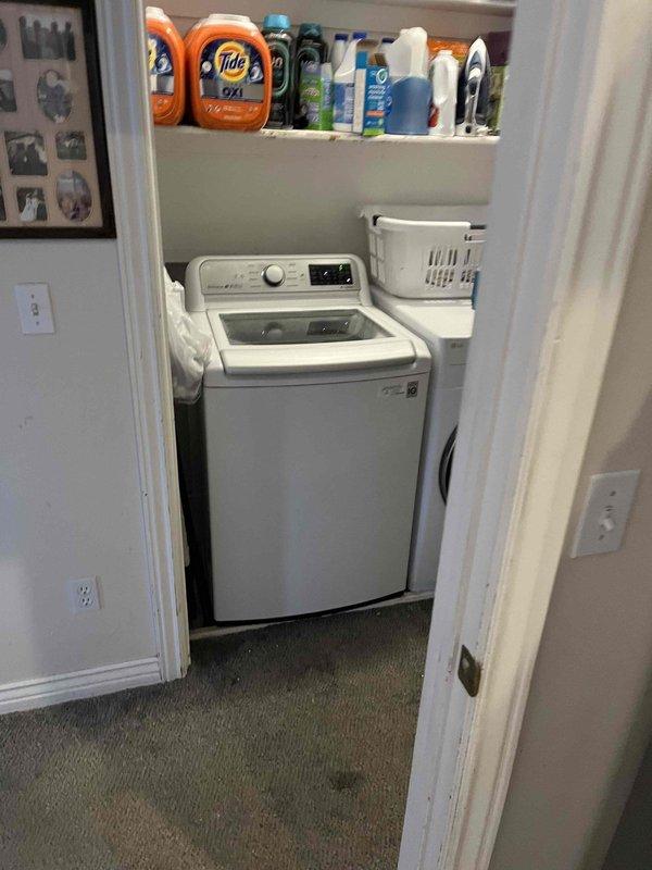 Responded to utility room drain backing up when washing machine discharged. Upon arrival, inspected laundry area and utility room containing water softener system and HVAC equipment. Located floor drain in utility room experiencing backup issues during washer drain cycles. Performed diagnostic inspection to identify cause of drainage obstruction and water leakage through drain fixture.